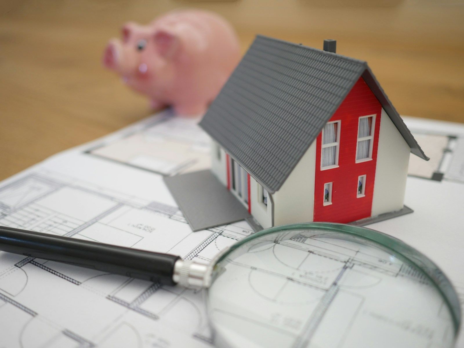 A model house and a magnifying glass on paperwork