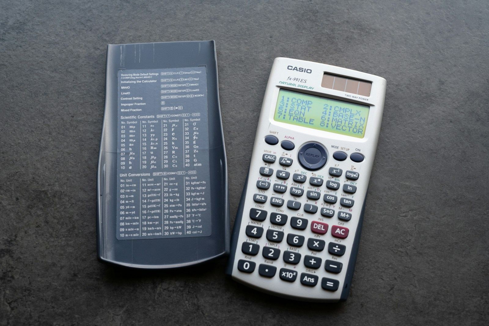 Two calculators on a dark table