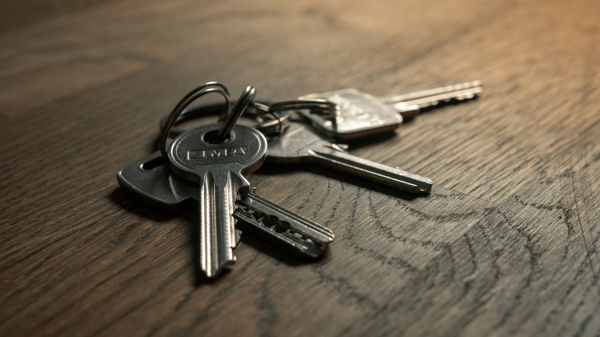 A set of house keys on a wooden table